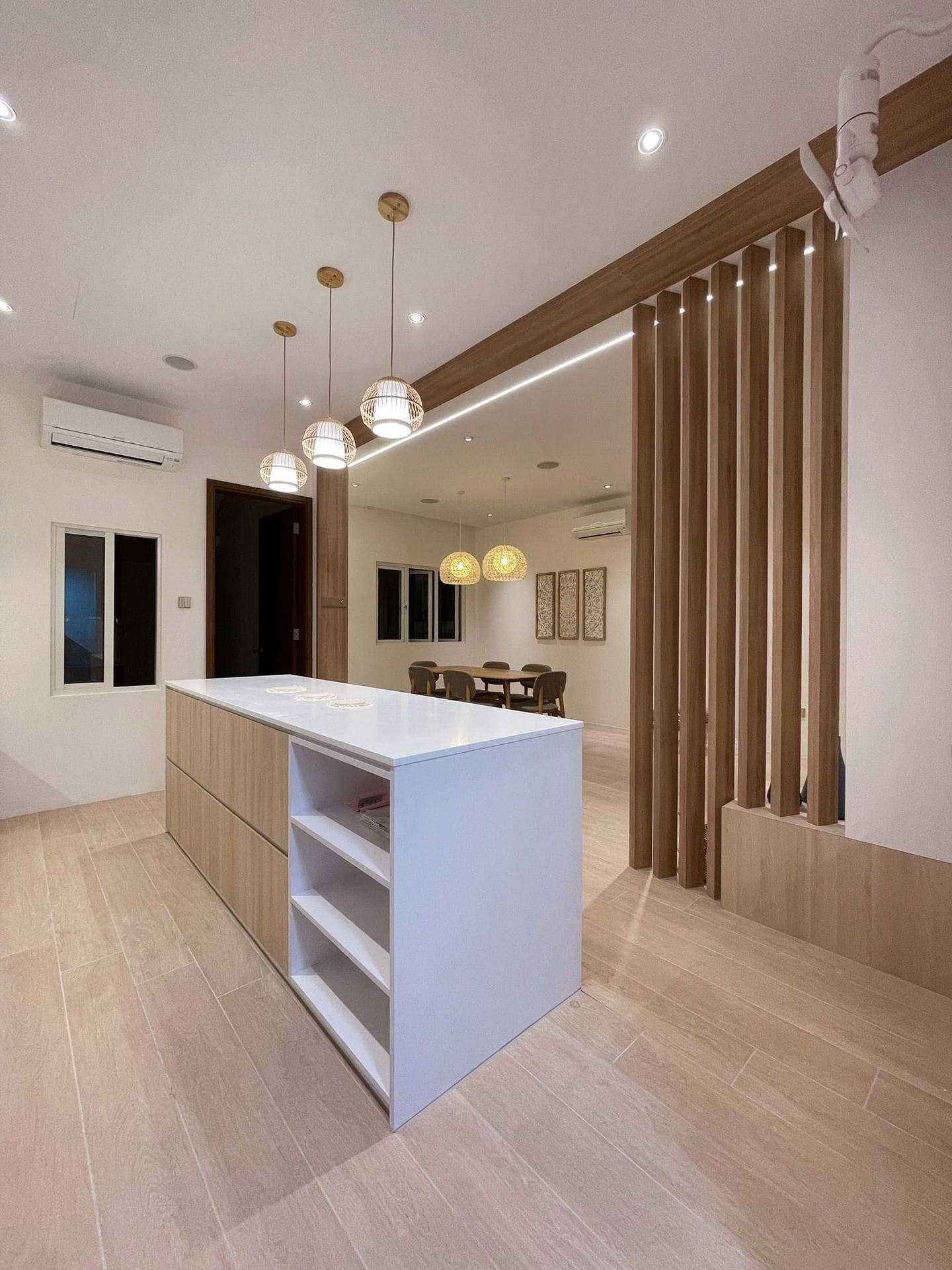 Minimalist HDB dining area featuring seamless warm woodgrain wall paneling and custom display cabinetry