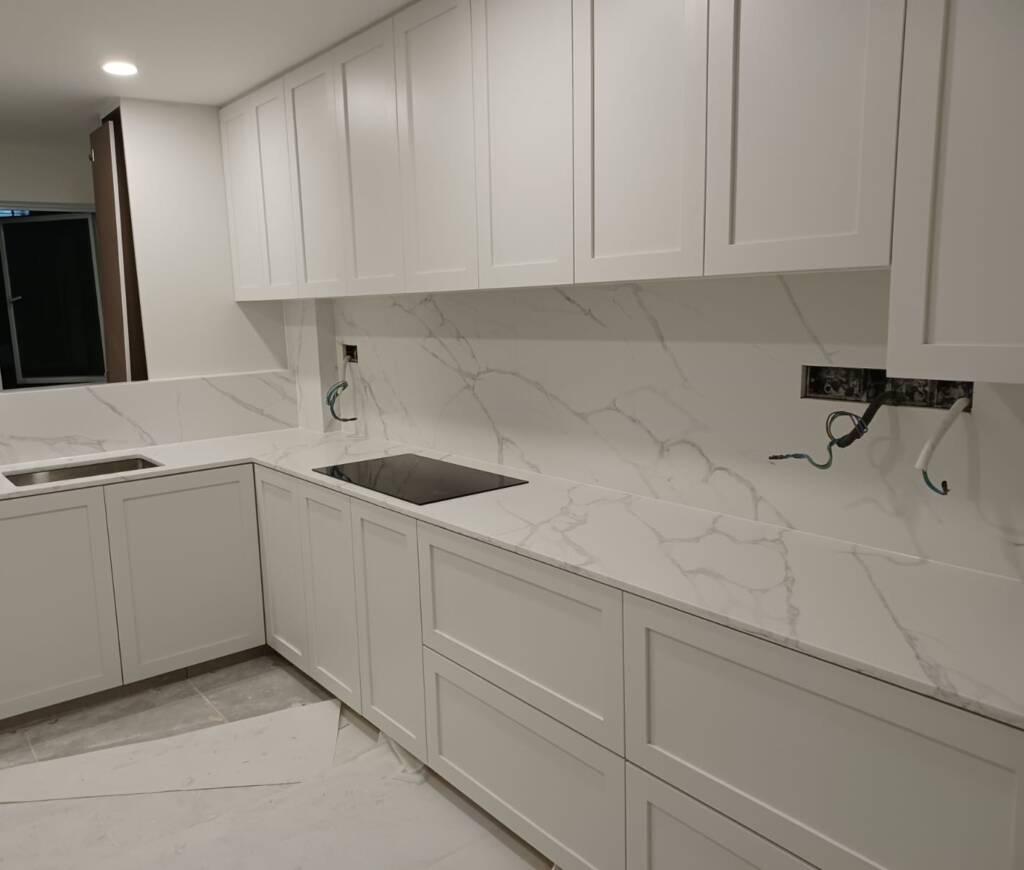 Modern open-concept HDB kitchen with anti-slam quartz countertops and dual-tone laminate cabinets